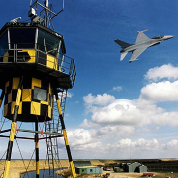 Landskab i Syddanmark med tårn i forgrunden og kampfly i baggrunden